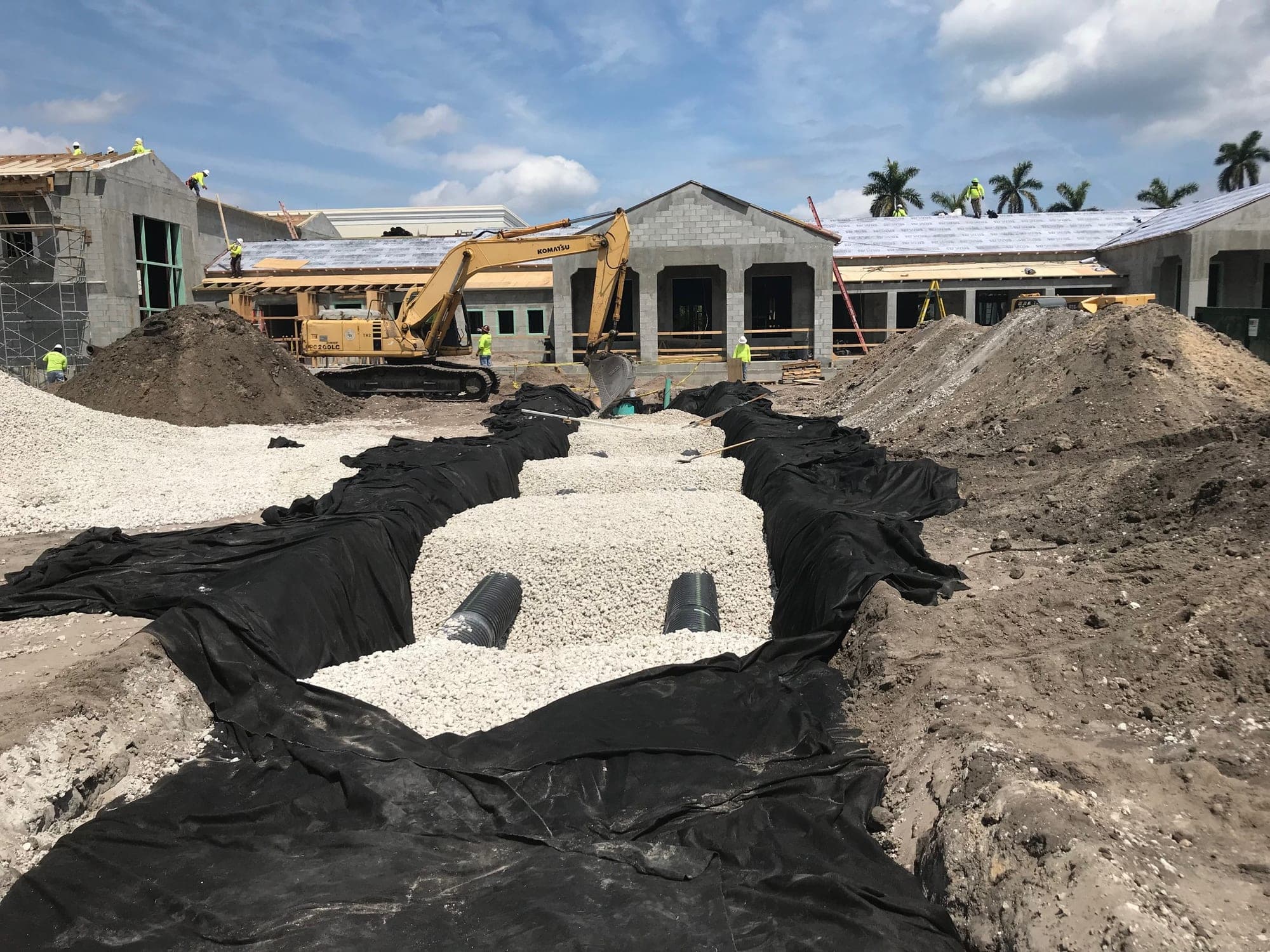 Concrete block commercial building under construction with excavator, Palm Beach County